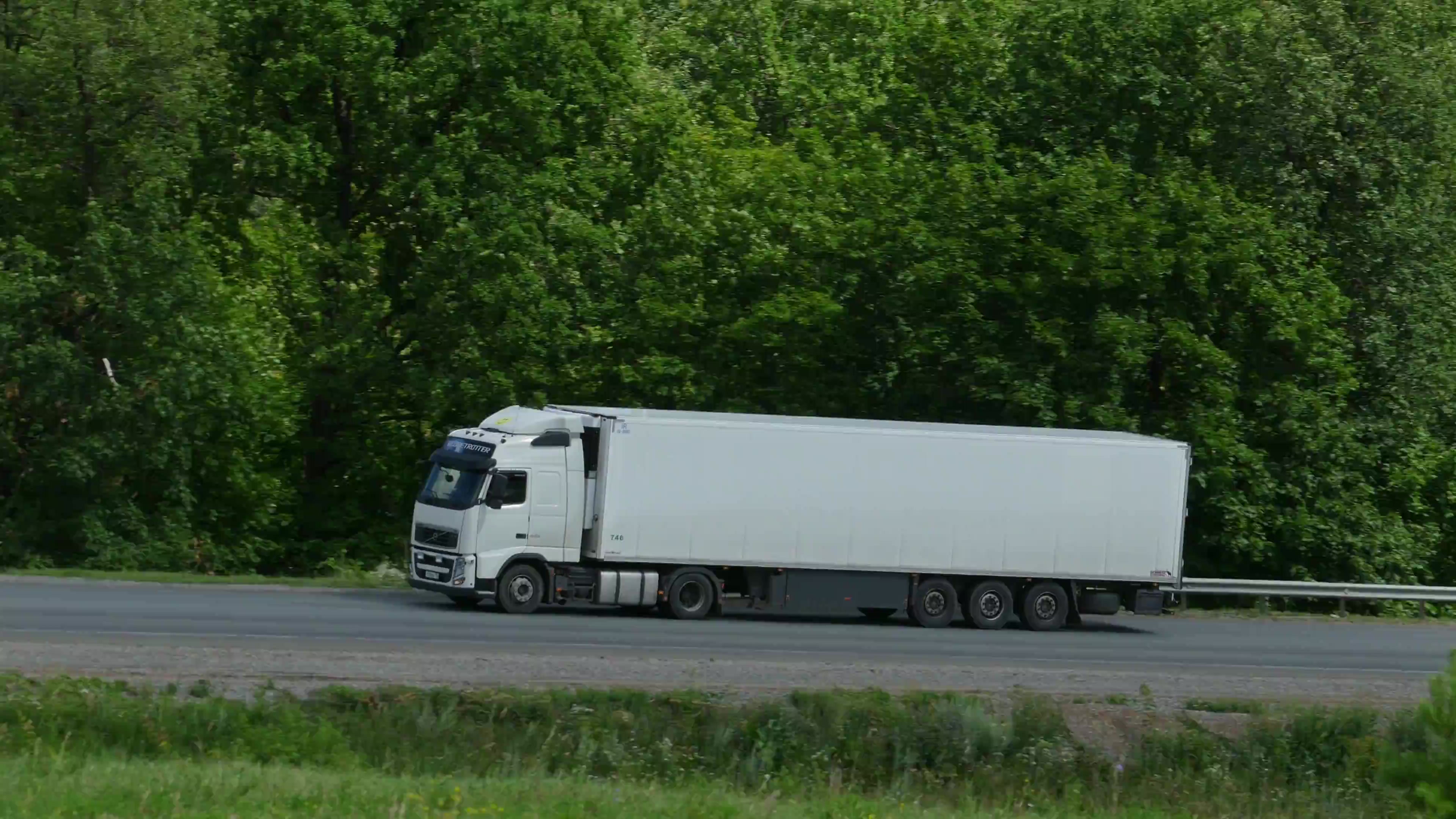 Collection lorry loaded with stacked timber pallets leaving a site