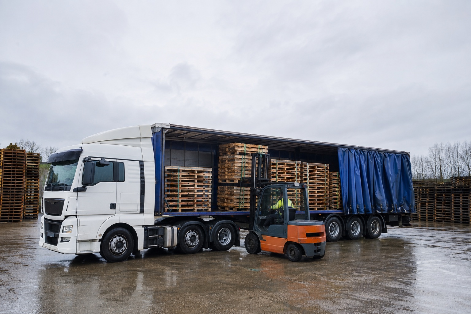 A curtain-side trailer being loaded with a large volume of timber pallets